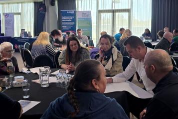 a group of people talking at yourvoice event